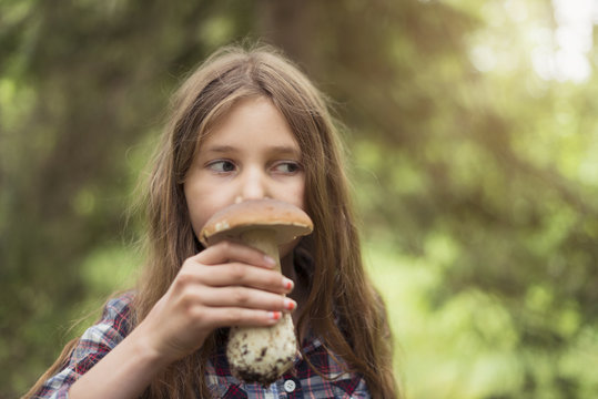 Girl smelling mushroom