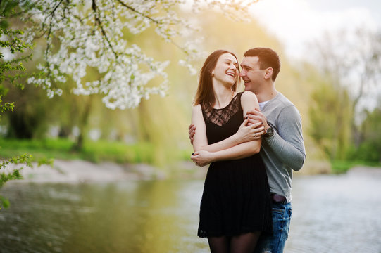 Young couple in love outdoor. Laugh and huggs background lake