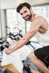 Smiling man on exercise bike looking at the camera