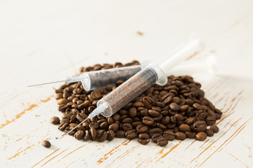 Health care concept - coffee beans in plastic syringe