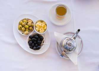 Traditional moroccan mint tea with olive on the table. Overhead close up view.