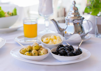 Moroccan olive and traditional mint tea on table. Close up. Focus on olive.