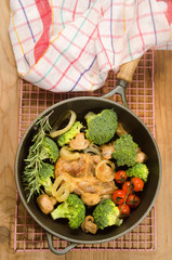 pork neck steak in a cast iron pan with vegetables