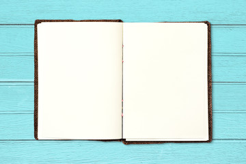 Open blank book on vintage blue wood background.