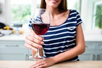 Young woman holding red wine glass