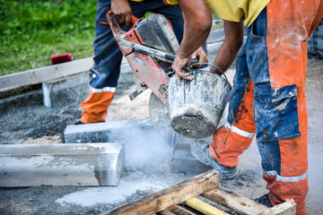 Construction worker cutting concrete paving stabs or metal for s - obrazy, fototapety, plakaty