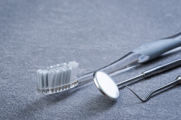 Basic dental tools and brush on grey surface