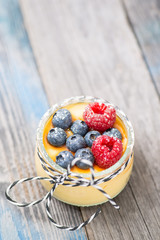 Jar with fresh yogurt and berries on table