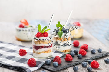 Jars with fresh yogurt and berries on table
