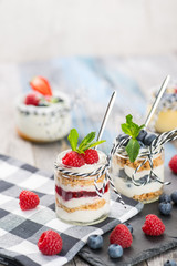 Jars with fresh yogurt and berries on table