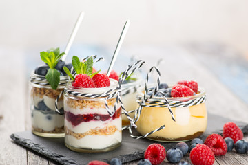 Jars with fresh yogurt and berries on table