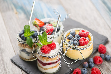 Jars with fresh yogurt and berries on table