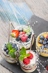 Jars with fresh yogurt and berries on table