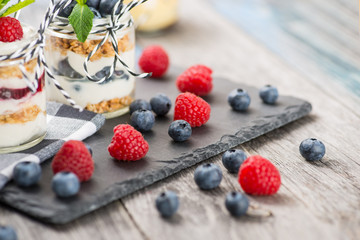 Jars with fresh yogurt and berries on table