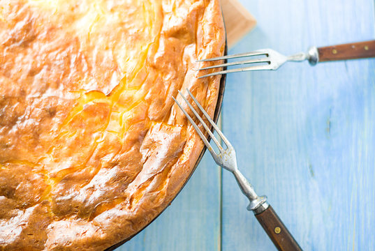 Cheese cake and two forks on blue
