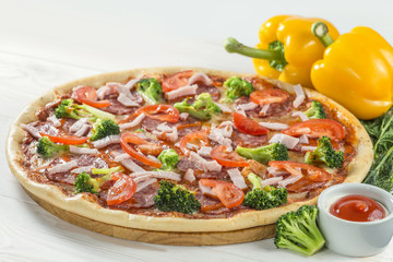 tasty pizza on a wooden board with beautiful vegetables and sauc