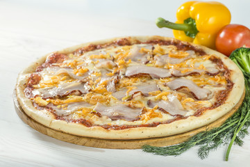 delicious pizza on wooden board with tomato and pepper