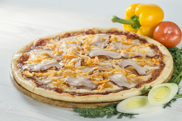 delicious pizza on wooden board with tomato and pepper