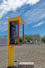 A public payphone with the receiver off the hook