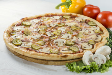 tasty pizza on a wooden board with pepper and mushrooms