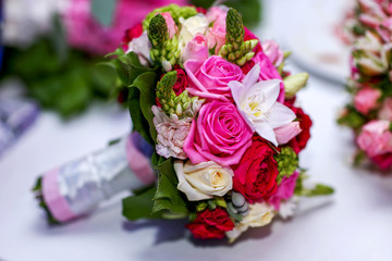 Wedding bouquet of bride colorful roses on the white table