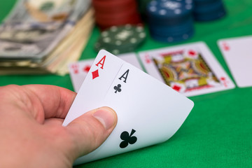 poker player holding playing cards with chips and money