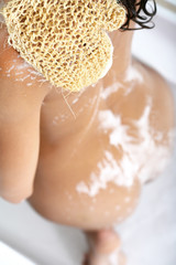 Fototapeta premium corps de femme nue sous la douche avec un gant de crin