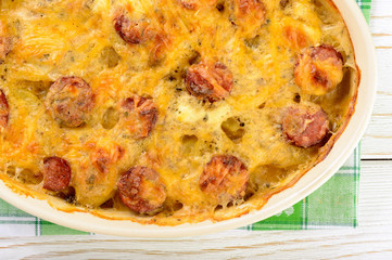 Casserole with potatoes, sausages, tomatoes and cheese.