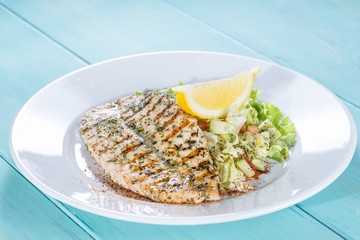 salmon fillet on the grill serve fresh salad and lemon