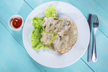 stew with gravy and leaves of fresh lettuce and sauce