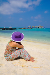 Fototapeta na wymiar women sit on Beautiful beach with water bungalows at Maldives.