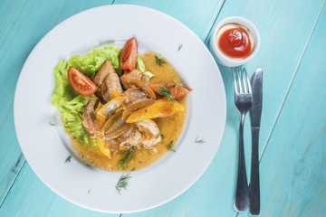 veal slices are served with sweet pepper, onion and fresh tomato