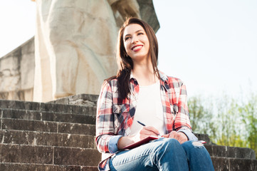 Outdoor relaxation concept with beautiful female and her diary