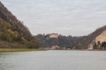 Wide Sava river flowing among hills and Rajhenburg castle on top of one of them.