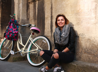 Fototapeta na wymiar Happy girl with vintage bicycle in old town