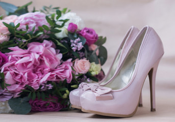 Beautiful wedding shoes with high heels and a bouquet of colorful flowers hydrangea, peonies and roses on a background of kraft paper, decorations, preparing for the wedding, details, boudoir