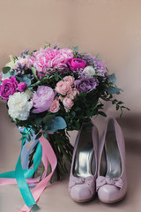 Beautiful wedding shoes with high heels and a bouquet of colorful flowers hydrangea, peonies and roses on a background of kraft paper, decorations, preparing for the wedding, details, boudoir