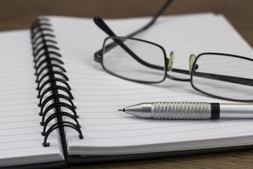 Black spiral bound notebook on wooden background