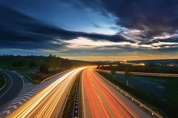 Rolgordijnen Zonsondergang met lange belichtingstijd boven een snelweg © tomaspic