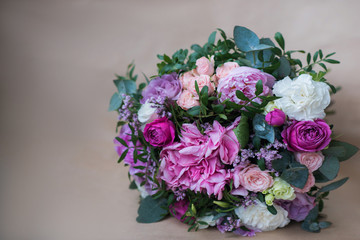 Beautiful bright wedding bouquet of hydrangea, peonies and roses on a background of kraft paper