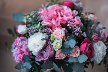 Beautiful bright wedding bouquet of hydrangea, peonies and roses on a background of kraft paper