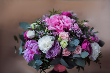 Beautiful bright wedding bouquet of hydrangea, peonies and roses on a background of kraft paper