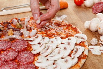 Cooking homemade traditional Italian delicious pizza four seasons