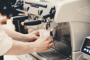 Barista preparing coffee in a cafe. Professional coffee making, service and catering concept