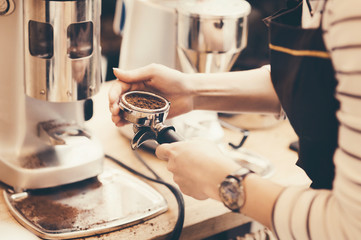 Barista grinding coffee beans for espresso