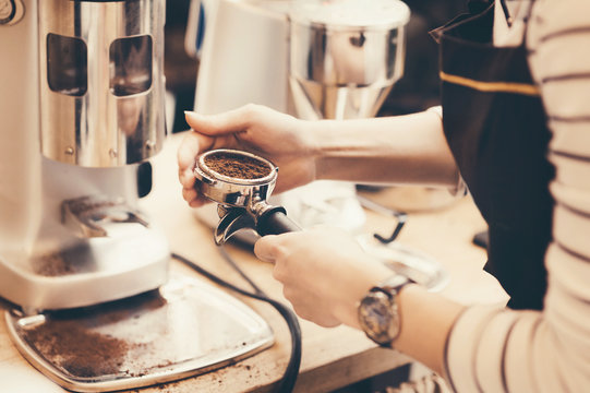 Barista grinding coffee beans for espresso