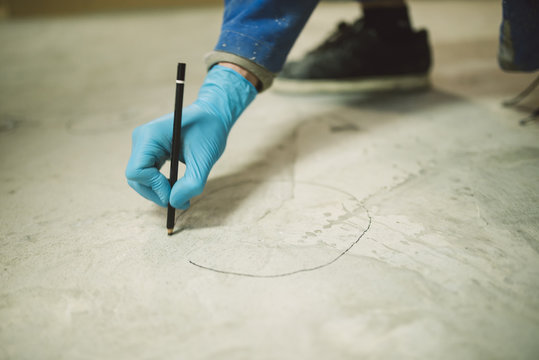 Bricklayer marking irregularities on floor screed