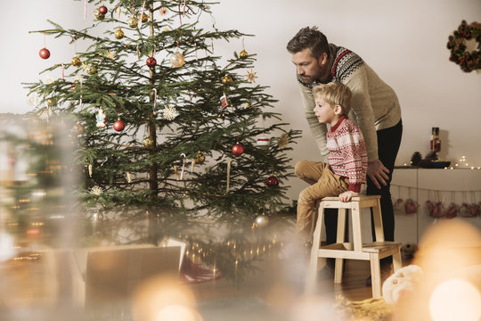 Father and son decorating Christmas tree