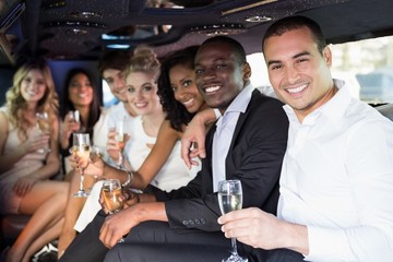 Well dressed people drinking champagne in a limousine - obrazy, fototapety, plakaty