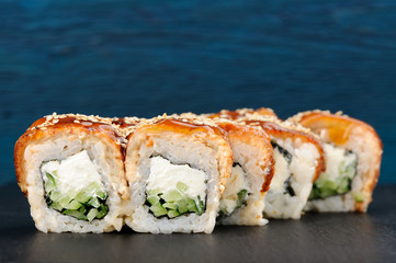 Yummy sushi rolls with cream cheese, nori and cucumber covered